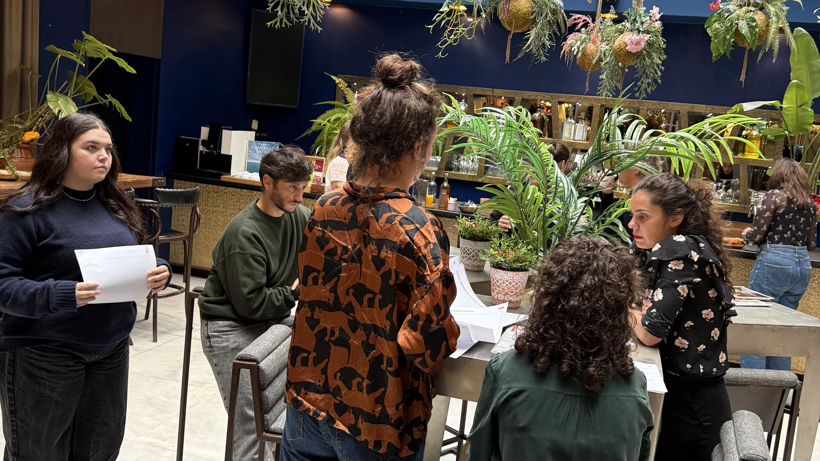 Participants debout autour d'une table avec les supports d'atelier, pendant un séminaire