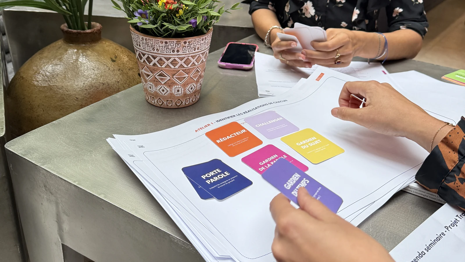 Cartes de rôles et supports d'atelier posés sur la table pendant un séminaire